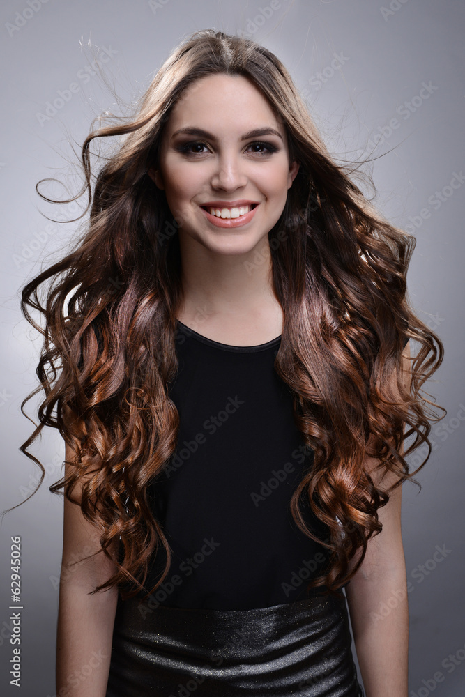 Beautiful young woman with long hair on grey background Beautiful young woman with long hair on grey background