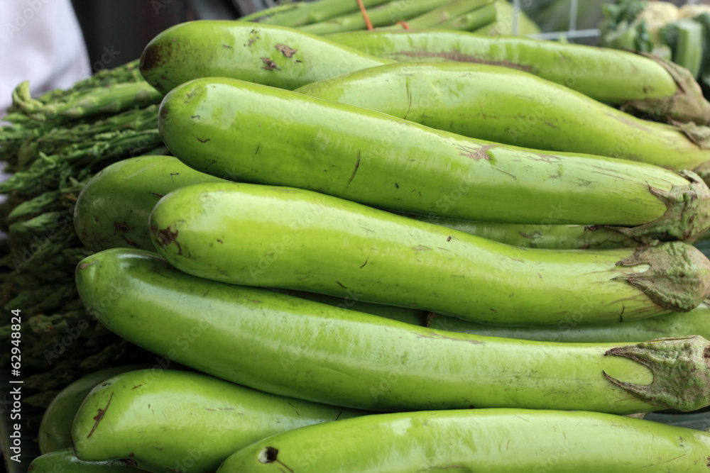 Green long eggplants in the market.
