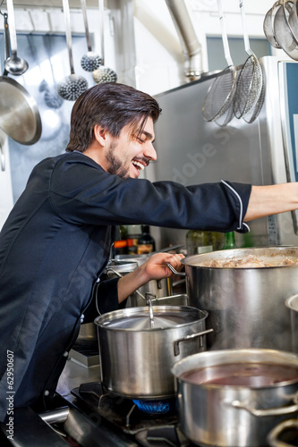 Chef stirring a huge pot of stew or casserole photo