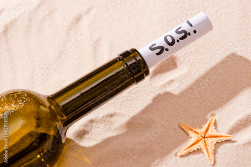 word SOS is written in the note in the bottle