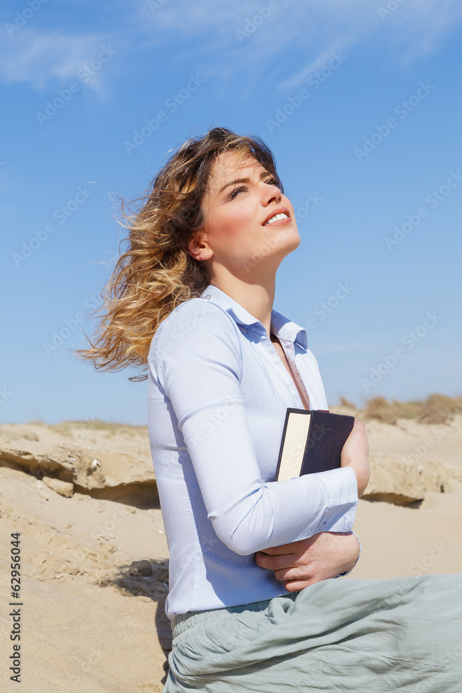 Beautiful blonde student girl relaxing on the beach Beautiful blonde student girl relaxing on the beach