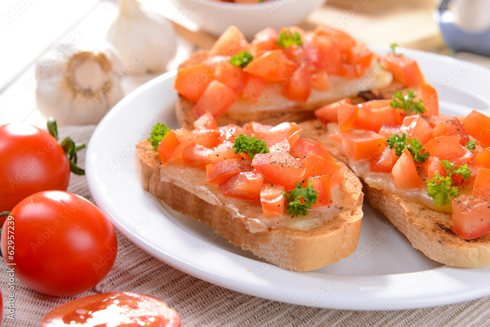 Delicious bruschetta with tomatoes on plate on table close-up Delicious bruschetta with tomatoes on plate on table close-up