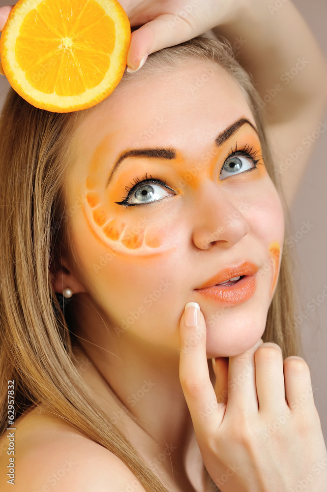 Young beautiful woman with creative orange makeup with orange Young beautiful woman with creative orange makeup with orange