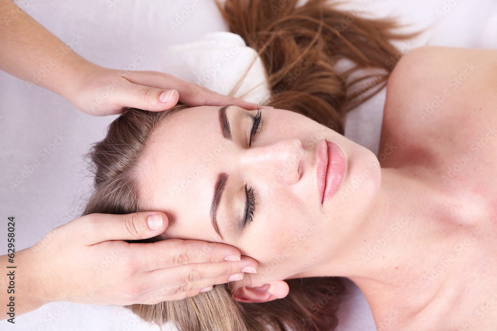 Fototapeta premium Beautiful young woman having head massage in spa salon