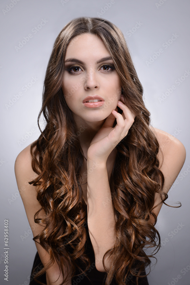 Obraz premium Beautiful young woman with long hair on grey background
