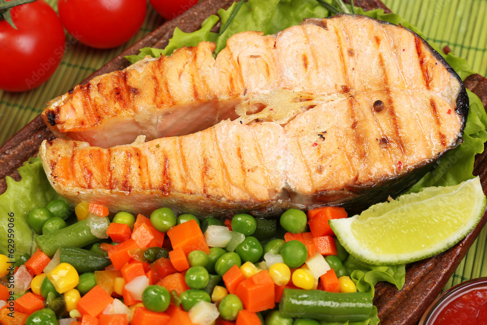 Tasty grilled salmon with vegetables, close up Tasty grilled salmon with vegetables, close up