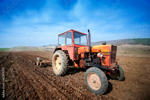 farmer working the fields with tractor and plow