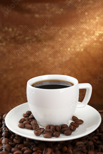 Fototapeta Naklejka Na Ścianę i Meble -  Coffee beans and cup of coffee on table on brown background