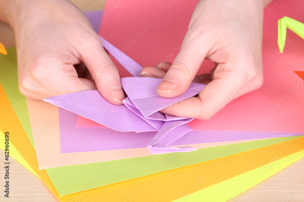 Hands making origami crane, close up Hands making origami crane, close up