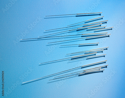 Needles for acupuncture on blue background