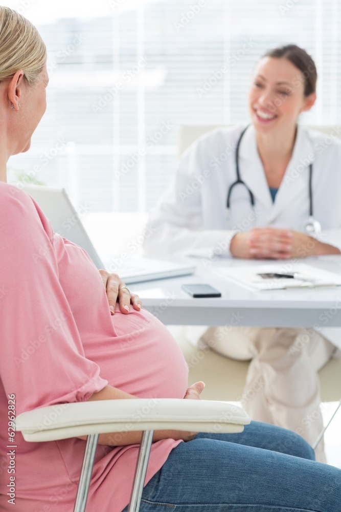 Pregnant woman consulting female doctor Pregnant woman consulting female doctor