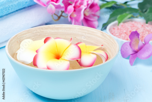flowers in a blue bowl and towels for the spa