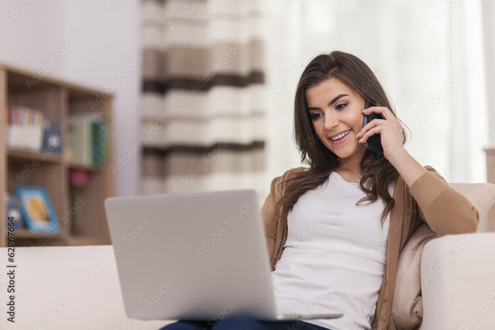 Attractive woman using laptop and smart phone at home Attractive woman using laptop and smart phone at home