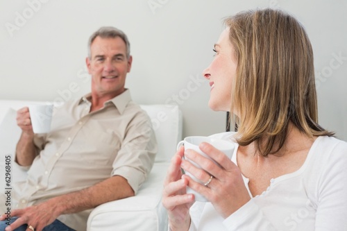 Relaxed couple with coffee cups in living room