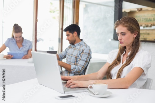 Wallpaper Mural Concentrated woman using laptop in coffee shop Torontodigital.ca