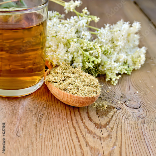Herbal tea of meadowsweet dried in spoon and mug