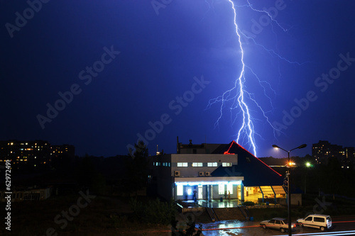 Severe lightning storm over a city buildings