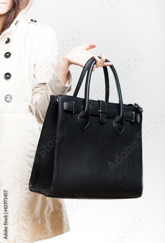Elegant woman in coat with black leather bag