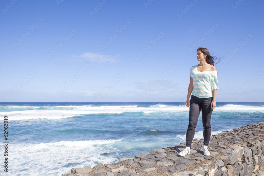 young beautiful woman walking near the sea
