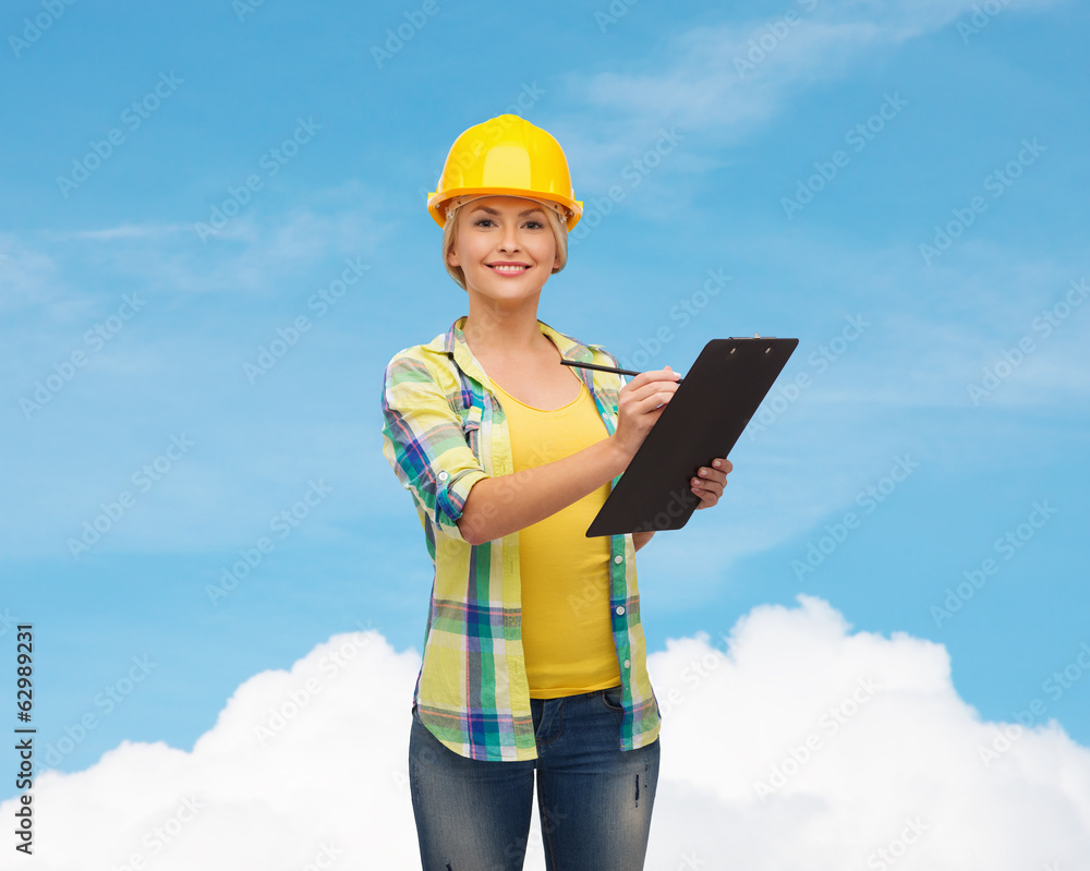 smiling woman in helmet with clipboard smiling woman in helmet with clipboard