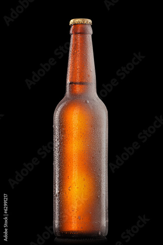 Beer bottle with water drops and frost isolated on black
