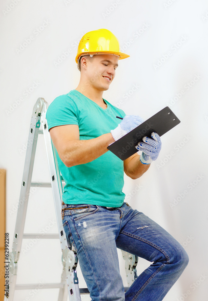smiling man in protective helmet with clipboard smiling man in protective helmet with clipboard