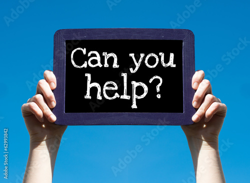 Foto Can you help ? Woman holding blackboard over blue background