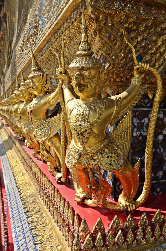 golden statues on the wall of the Grand Palace