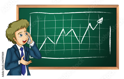 A man using his cellular phone in front of the board