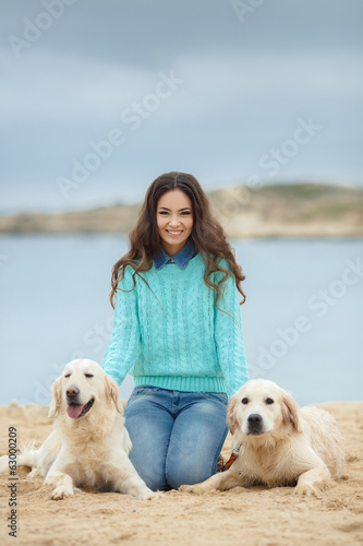 portrait of Beautiful woman with her dog on the beach near sea