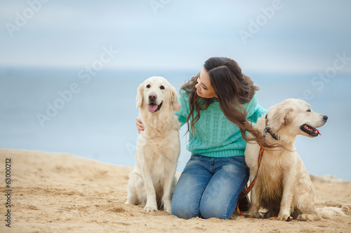portrait of Beautiful woman with her dog on the beach near sea