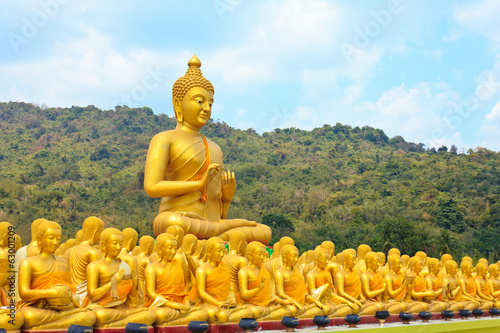 Many buddha statue under blue sky in temple