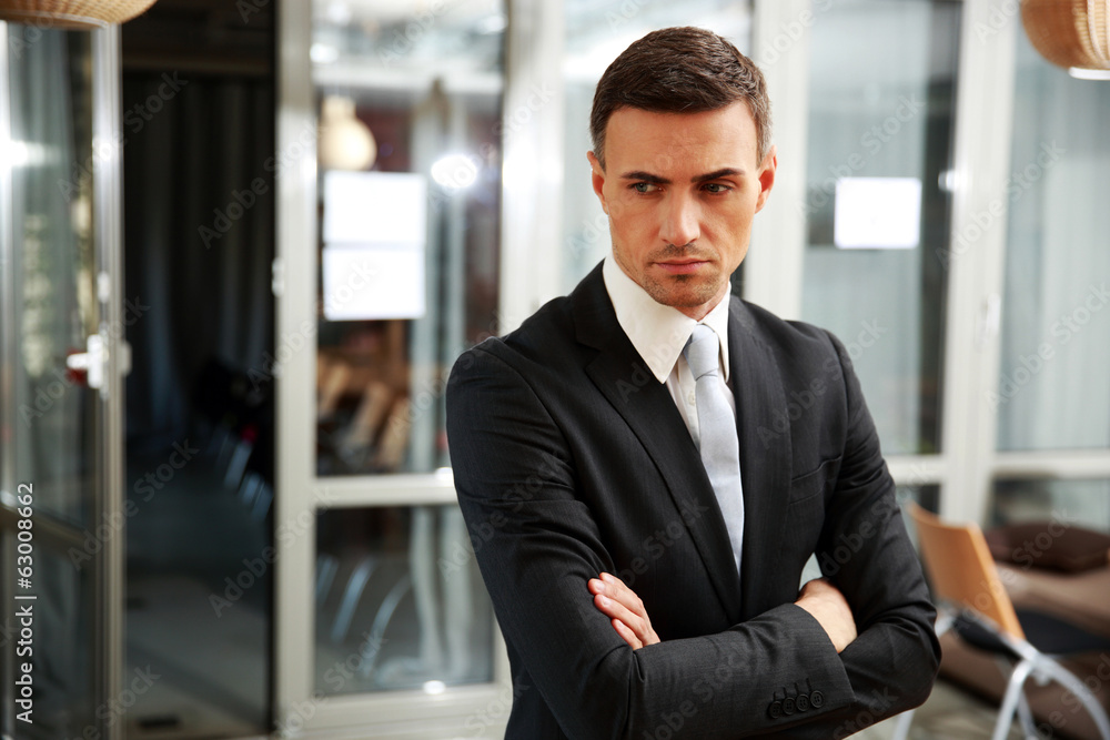 Pensive businessman standing at office Pensive businessman standing at office