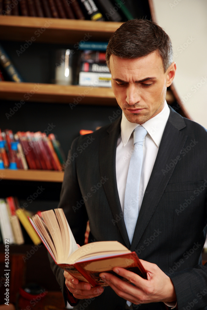 Businessman reading the book in library Businessman reading the book in library