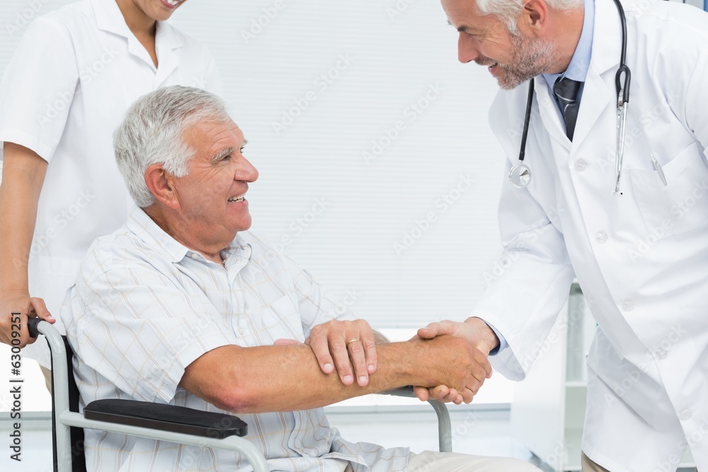 Smiling senior patient and doctor shaking hands Smiling senior patient and doctor shaking hands