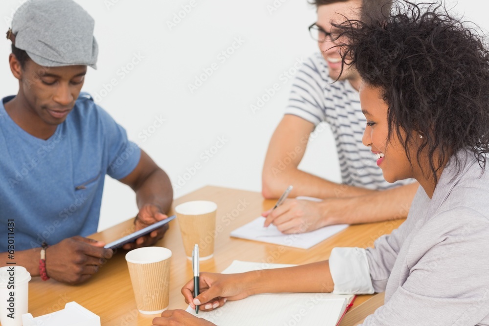 Group of happy artists in discussion at desk Group of happy artists in discussion at desk