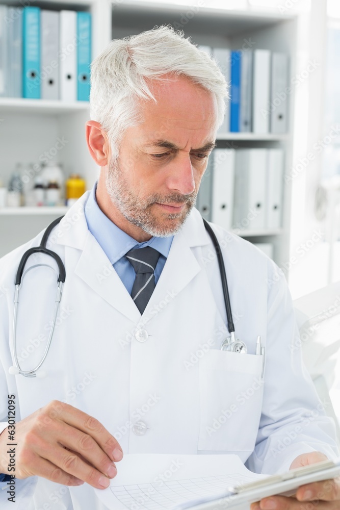 Doctor looking at reports in the medical office Doctor looking at reports in the medical office
