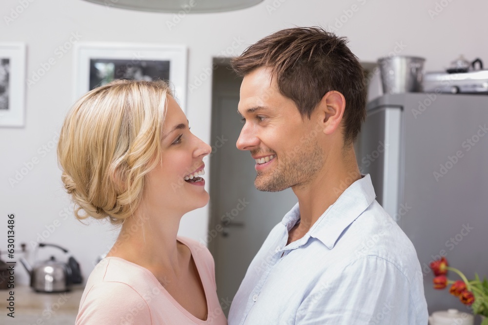 Obraz premium Loving couple looking at each other in the kitchen