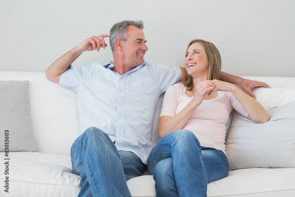 Happy relaxed couple sitting on sofa in living room