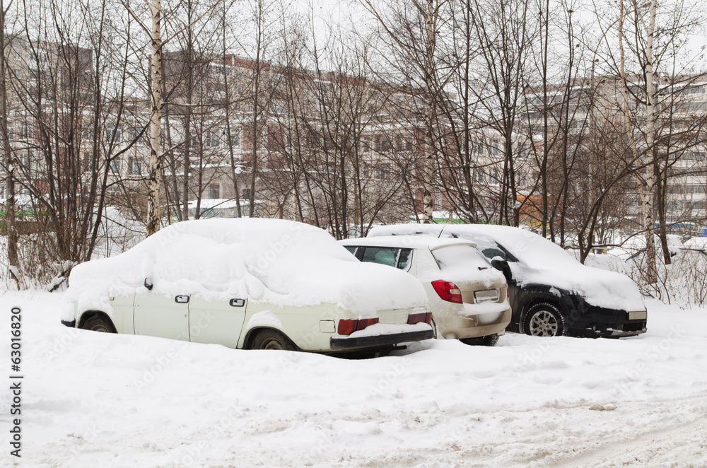 Cars under snow on parking
