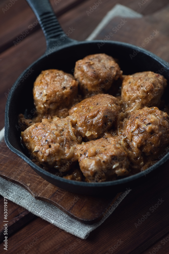 Frying pan with meatballs, rustic wooden background, close-up Frying pan with meatballs, rustic wooden background, close-up