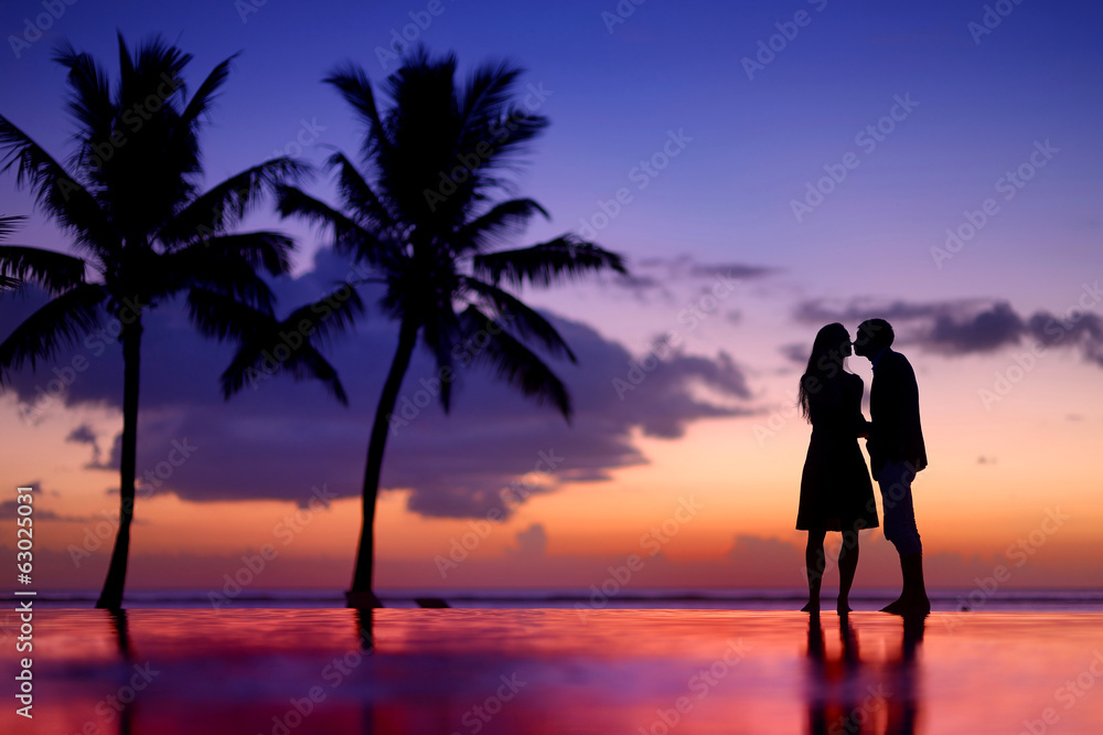 Silhouettes of young couple at scenic sunset