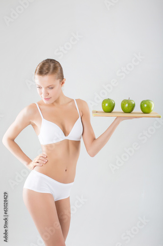 Athletic young woman holding a green apple