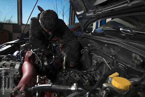 Car repairman examining an old car