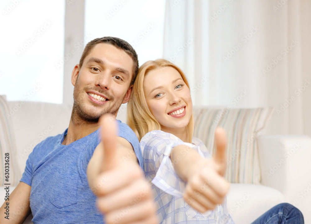 smiling happy couple at home showing thumbs up smiling happy couple at home showing thumbs up