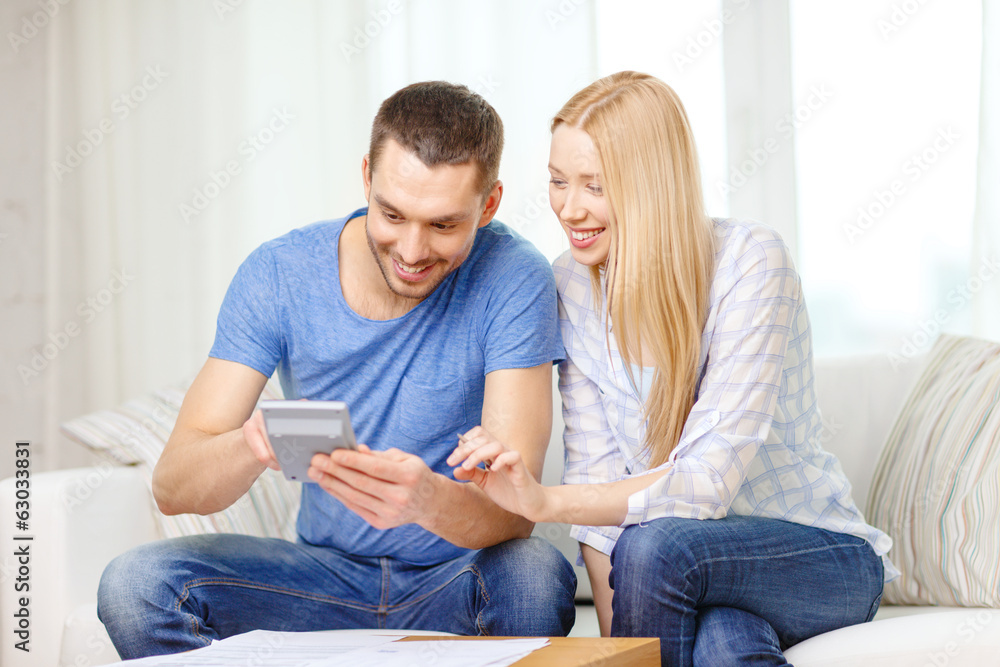 smiling couple with papers and calculator at home smiling couple with papers and calculator at home