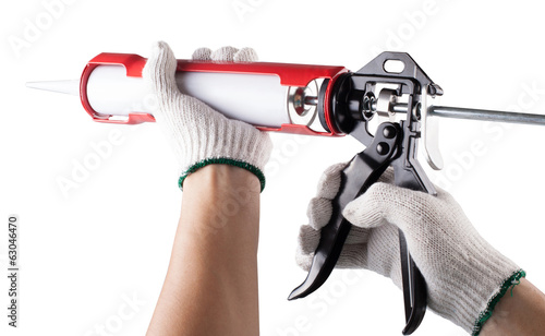 Worker applies silicone caulk gun isolated on white background