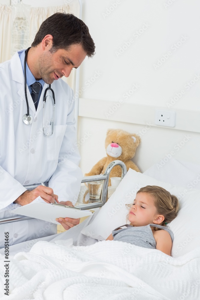 Obraz premium Doctor writing on clipboard while attending ill girl