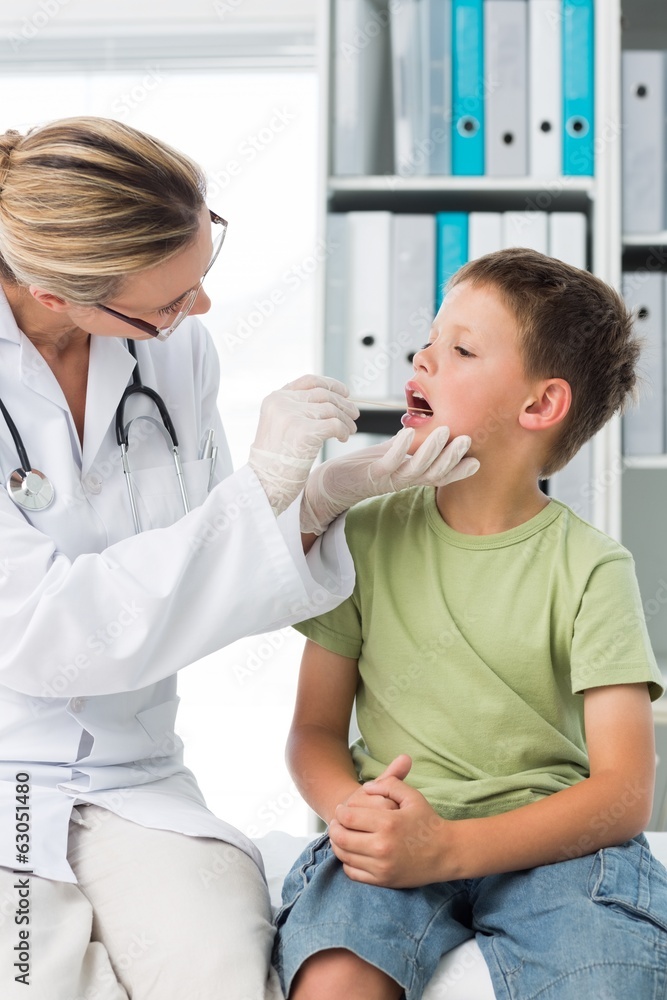 Fototapeta premium Doctor examining mouth of little boy