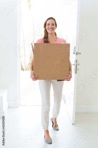 Woman carrying cardboard box in new house